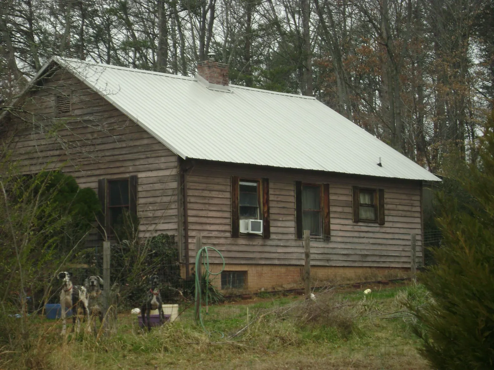 White metal roof on an old wood sided farmhouse, from a Metal Roof Installation job in Jacksonville